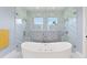 Luxurious bathroom showcasing a freestanding tub, glass shower, and elegant tile work at 1702 Hidden Palms Dr, Davenport, FL 33897