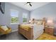 Sunlit bedroom featuring a wooden bed frame, a ceiling fan and gray wood floors at 1702 Hidden Palms Dr, Davenport, FL 33897