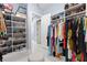Bright walk-in closet featuring shoe racks, hanging storage, and a central ottoman at 1702 Hidden Palms Dr, Davenport, FL 33897