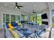 Stylish covered patio with comfortable seating, ceiling fans and a tv and fireplace at 1702 Hidden Palms Dr, Davenport, FL 33897