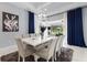 Elegant dining room with a large white table, seating for eight, and stylish chandelier, adjacent to the pool area at 1702 Hidden Palms Dr, Davenport, FL 33897
