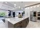 A designer kitchen with an island with seating, stainless steel appliances, and marble countertops, open to other living spaces at 1702 Hidden Palms Dr, Davenport, FL 33897