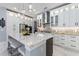 Spacious kitchen features white cabinets, a large marble island with seating, and modern stainless steel appliances at 1702 Hidden Palms Dr, Davenport, FL 33897