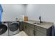 Laundry room featuring front loading washer and dryer, stylish countertop, and stainless steel sink at 1702 Hidden Palms Dr, Davenport, FL 33897