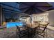 This property features a screened-in pool area complete with poolside dining and lounge furniture and ambient lighting at 1702 Hidden Palms Dr, Davenport, FL 33897