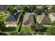 An aerial view of a beige two-story home featuring a dark roof and a fenced backyard at 20945 Oldenburg Loop, Mount Dora, FL 32757
