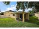 Exterior back view of home showing large yard and screened in patio at 20945 Oldenburg Loop, Mount Dora, FL 32757