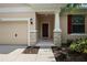 Inviting front entrance with stone accents and a covered porch leading to a wood door at 20945 Oldenburg Loop, Mount Dora, FL 32757