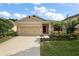 Charming home featuring a two-car garage, landscaped front yard, and covered entryway at 20945 Oldenburg Loop, Mount Dora, FL 32757