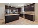 Beautiful kitchen features stainless steel appliances, dark wood cabinets, an island, and tile floors at 20945 Oldenburg Loop, Mount Dora, FL 32757