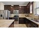 Kitchen with stainless steel appliances, tile backsplash, and dark wood cabinets at 20945 Oldenburg Loop, Mount Dora, FL 32757