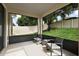 A patio with two chairs and a small table with a view of a lush green yard and fence at 20945 Oldenburg Loop, Mount Dora, FL 32757
