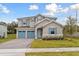 Charming two-story home with a three-car garage, beautiful landscaping, and blue shutters at 2208 Keystone Pass Blvd, Minneola, FL 34715