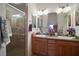 Bright bathroom features double sinks, wood cabinets and a glass enclosed shower at 2265 Hackney Way, The Villages, FL 32162