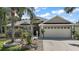 Charming single-story home featuring a well-manicured lawn, mature landscaping, and a two-car garage on a sunny day at 2265 Hackney Way, The Villages, FL 32162