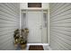 Welcoming front entry with a neutral-colored door, sidelights, and decorative potted plant creating an inviting entrance at 2265 Hackney Way, The Villages, FL 32162