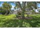 Landscaped front yard features a lush lawn, mature trees, and colorful plantings, offering great curb appeal at 2265 Hackney Way, The Villages, FL 32162