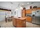 Bright kitchen with wooden cabinets, stainless steel appliances, an island, and an adjacent dining area for convenient meals at 2265 Hackney Way, The Villages, FL 32162
