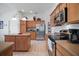 Well-equipped kitchen boasting stainless steel appliances, wood cabinets, and an island for efficient meal preparation and dining at 2265 Hackney Way, The Villages, FL 32162