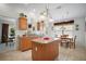 Functional kitchen featuring a center island, wood cabinets, and a seamless transition to the dining area for easy access at 2265 Hackney Way, The Villages, FL 32162