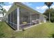 Screened in porch with ceiling fan and furniture, overlooking a lawn at 2265 Hackney Way, The Villages, FL 32162