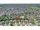 Aerial view of a residential neighborhood with the home indicated by a red arrow near the community pool at 2369 Unity Ter, The Villages, FL 32162