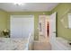 Bedroom with closet doors, doorway with hallway view, and white furnishings at 2369 Unity Ter, The Villages, FL 32162