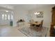 Open-concept dining area with tile flooring, a rustic table set, and seamless flow into the foyer at 2369 Unity Ter, The Villages, FL 32162