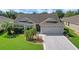 Beautiful one-story home with manicured lawn, lovely landscaping, and a convenient two-car garage at 2369 Unity Ter, The Villages, FL 32162