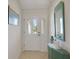Bright foyer with ceramic tile flooring, a decorative mirror, and a view through the glass-paneled front door at 2369 Unity Ter, The Villages, FL 32162