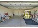 Spacious garage featuring epoxy flooring, plenty of storage, and a golf cart at 2369 Unity Ter, The Villages, FL 32162