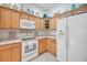 Bright kitchen features wooden cabinetry, white appliances, and neutral countertops at 2369 Unity Ter, The Villages, FL 32162