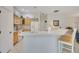 Kitchen with breakfast bar featuring natural wood cabinets and white countertops at 2369 Unity Ter, The Villages, FL 32162