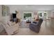 Spacious living area with tile flooring, ceiling fan, and patio access, ideal for comfortable living at 2369 Unity Ter, The Villages, FL 32162