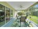 Relaxing screened patio with ceiling fan, outdoor dining table, and views of the lush backyard at 2369 Unity Ter, The Villages, FL 32162