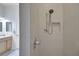 Close-up of the walk-in shower featuring tile walls and a shower head at 2369 Unity Ter, The Villages, FL 32162