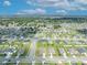 High-angle aerial view highlighting a neighborhood with orderly streets and houses under a partly cloudy sky at 2488 Begonia St, Mascotte, FL 34753