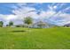 Lush green backyard featuring well-maintained lawn and a young shade tree at 2488 Begonia St, Mascotte, FL 34753