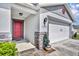 Welcoming front entrance with a red door, brick accents, and manicured landscaping at 2488 Begonia St, Mascotte, FL 34753