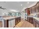 Well-equipped kitchen with stainless steel dishwasher and appliances, plus dark wood cabinets and wood floors at 2488 Begonia St, Mascotte, FL 34753