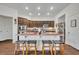 Modern kitchen featuring a large island with seating, stainless steel appliances, and dark wood cabinetry at 2488 Begonia St, Mascotte, FL 34753
