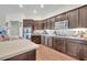 Kitchen view showcasing dark wood cabinets, countertops, stainless steel appliances, and modern fixtures at 2488 Begonia St, Mascotte, FL 34753
