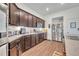 Kitchen featuring stainless steel appliances, ample counter space, dark cabinets and wood-look flooring at 2488 Begonia St, Mascotte, FL 34753
