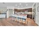 Modern kitchen island with dark cabinetry, seating for four, and stainless steel appliances at 2488 Begonia St, Mascotte, FL 34753