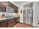 Kitchen showcasing stainless steel refrigerator, dark cabinets and counter space at 2488 Begonia St, Mascotte, FL 34753