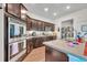 Kitchen displaying stainless steel appliances, ample counter space and dark wood cabinets at 2488 Begonia St, Mascotte, FL 34753