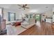 Spacious living room featuring a ceiling fan, ample seating, and natural light from large windows at 2488 Begonia St, Mascotte, FL 34753