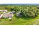 Aerial view showcases the home with a screened lanai surrounded by lush trees in a peaceful community setting at 26338 Glen Eagle, Leesburg, FL 34748