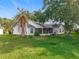 Spacious backyard view featuring a screened-in patio area and lush green lawn with mature trees and landscaping at 26338 Glen Eagle, Leesburg, FL 34748