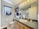 A bathroom featuring tile flooring, a wide mirror with vanity lights, and a neutral color scheme at 26338 Glen Eagle, Leesburg, FL 34748